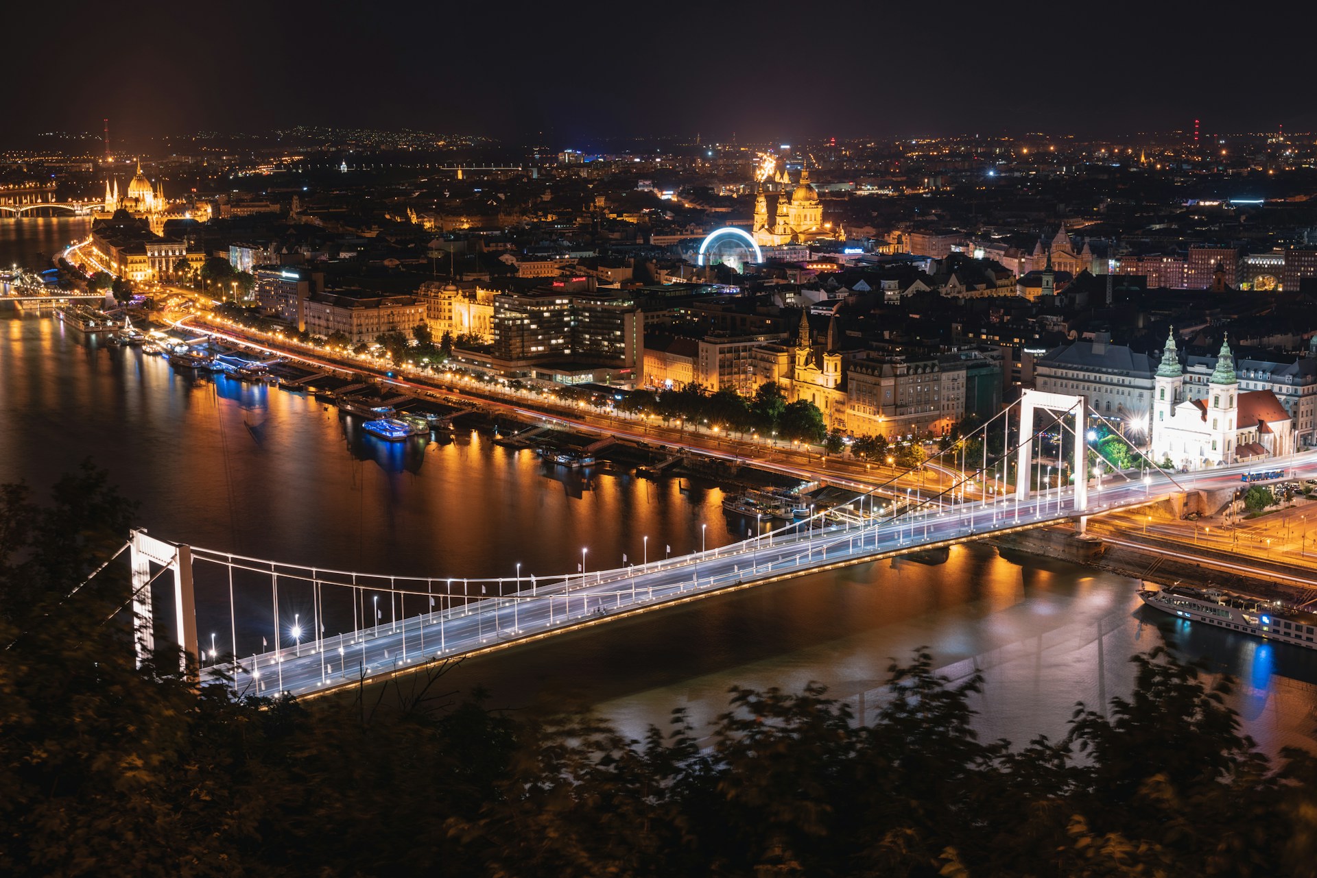 Illuminated European capital skyline at night with river and bridge